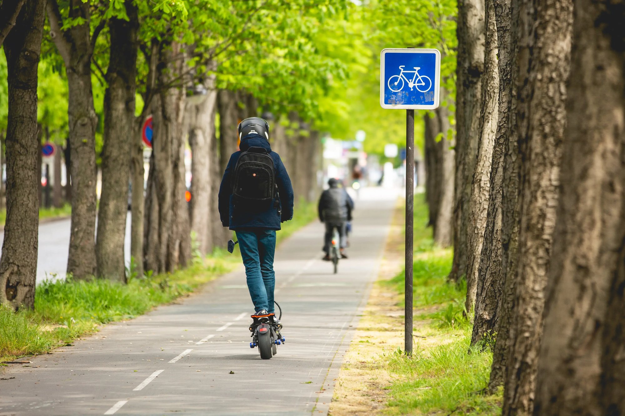 Scooter e ciclista na ciclovia